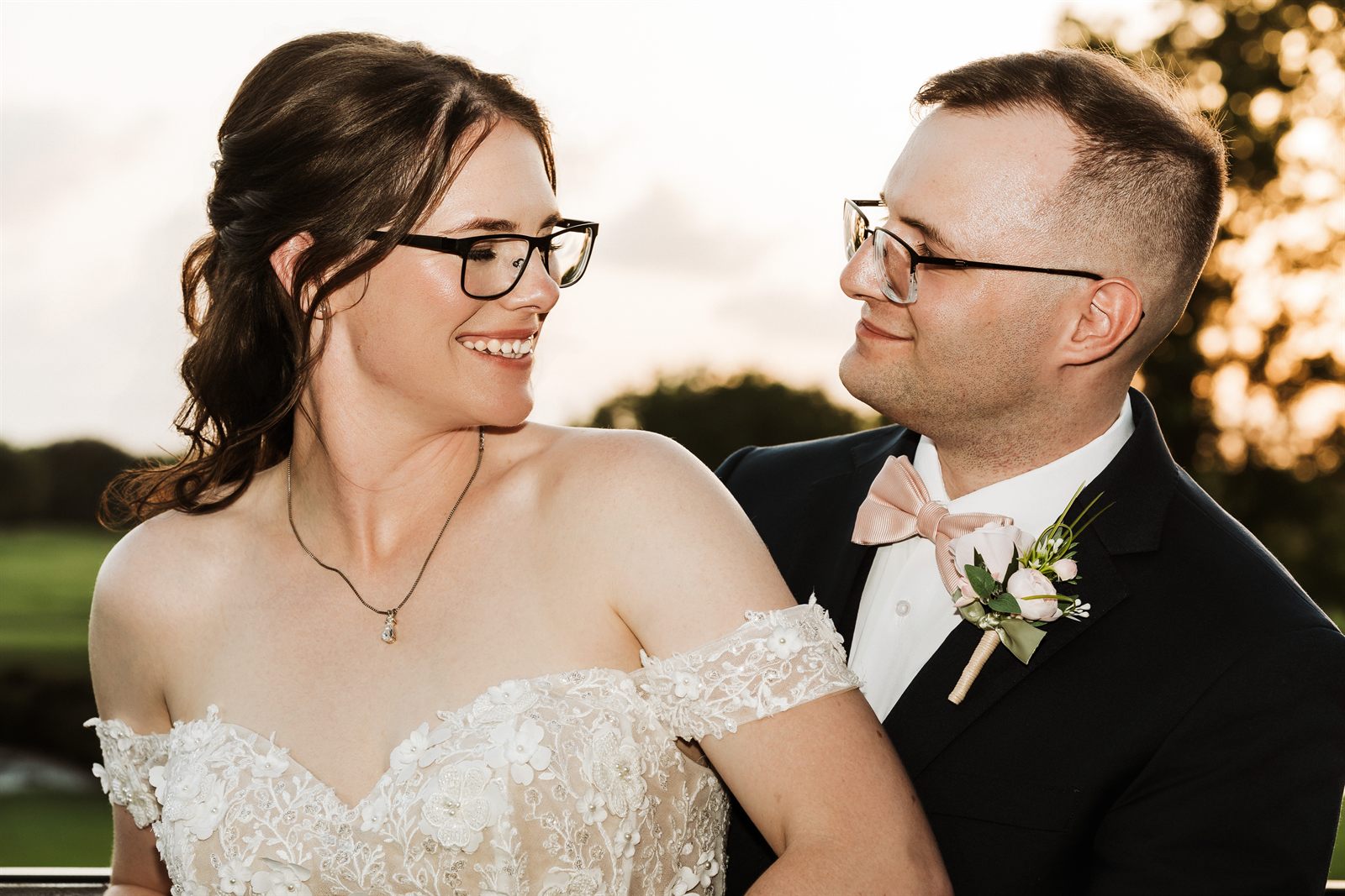 Bride and groom smiling at each other at golden hour